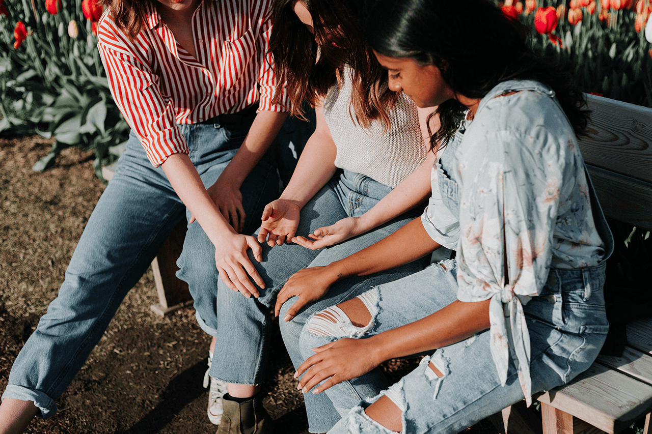 A small group of children sitting together outside
